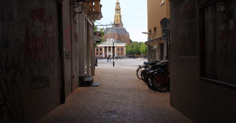 Doorkijkje vanuit Het Koude Gat naar de Vismarkt met de Korenbeurs. Foto door Aliese Oostmeijer tijdens fototour I Go Groningen 6 juni 2020